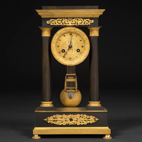19th century French Empire period table clock with two columns in blued bronze and gilded bronze.