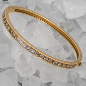 Pulsera rígida en oro amarillo de 18kt con frontal orlado de diamantes talla brillante y talla princesa.