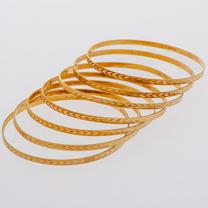 Conjunto de siete pulseras rígidas en oro amarillo de 18 Kt con decoración grabada.