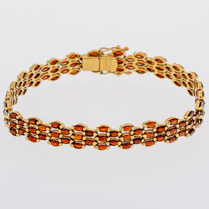 Pulsera en oro amarillo de 18 Kt con piedras de color rojo.