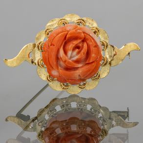Elegant 18kt yellow gold brooch with a carved red coral flower.