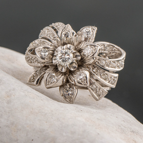 18kt white gold ring in the shape of a flower studded with diamonds.