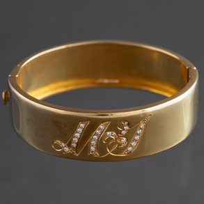 Rigid bracelet in 18kt yellow gold with two initials studded with diamonds.