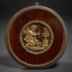 “Cupid” Medallion in walnut wood with gilded bronze applications of the nineteenth century.
