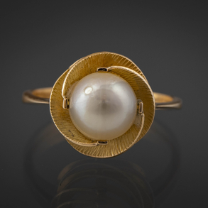 Anillo en forma de flor en oro amarillo de 18 kt con perla central.