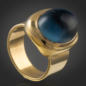 Anillo en oro amarillo de 18kt con piedra central color azul  en cabujón.