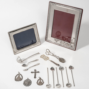 Miscelánea de piezas de plata compuesto por medallas, dos portafotos y cucharas en plata española y punzonada del siglo XX.