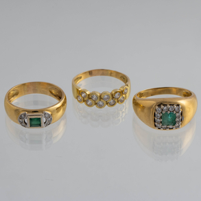 Conjunto de tres anillos en oro amarillo de 18kt con circonitas y esmeraldas.