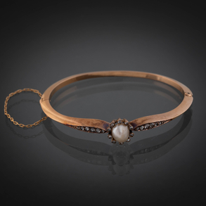 Pulsera rígida en oro amarillo de 18kt con perla y hombros con brillantes talla antigua.